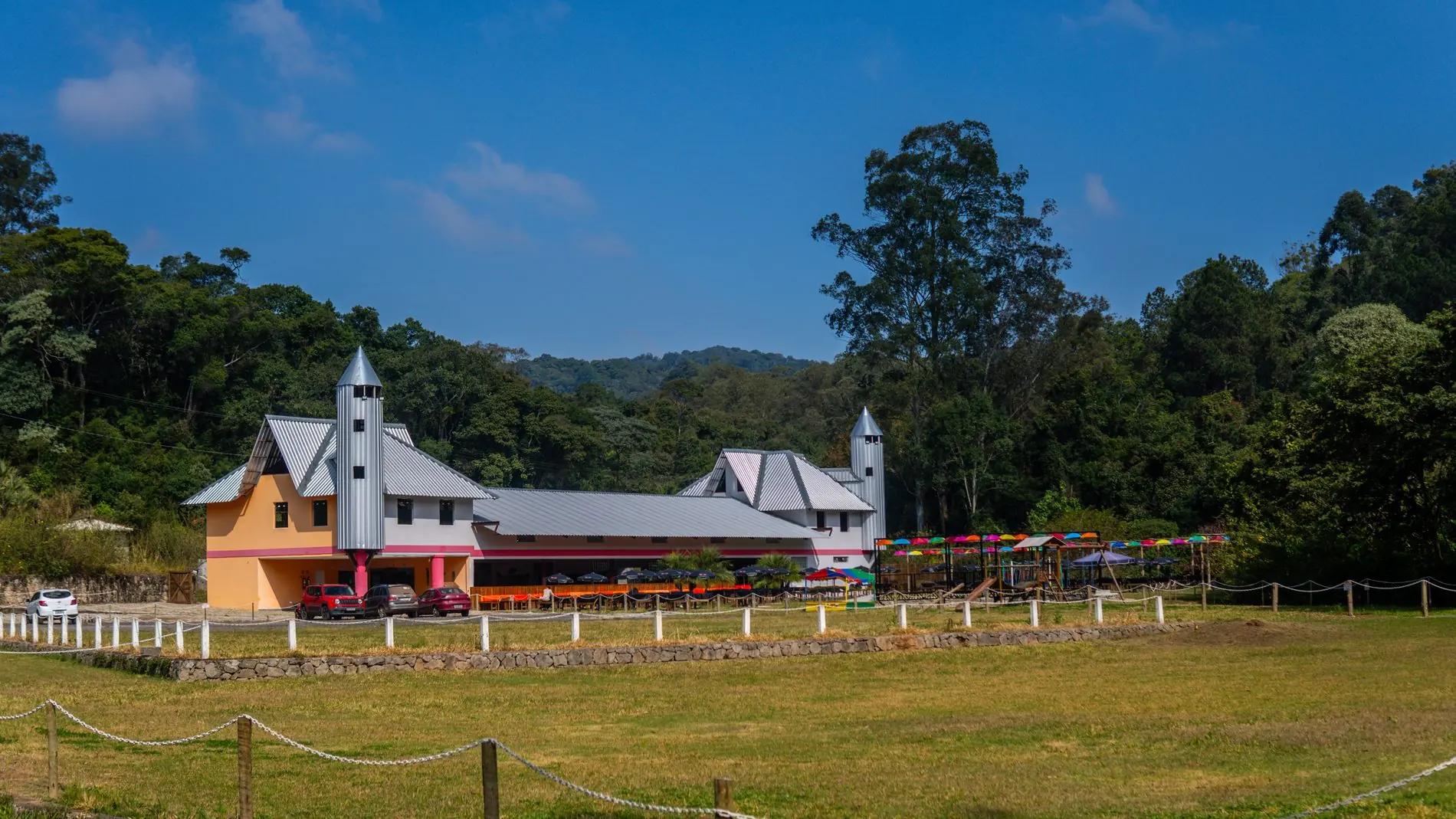 Vista panorâmica do Rancho Santa Inês com o campo aberto e a serra da Cantareira ao fundo