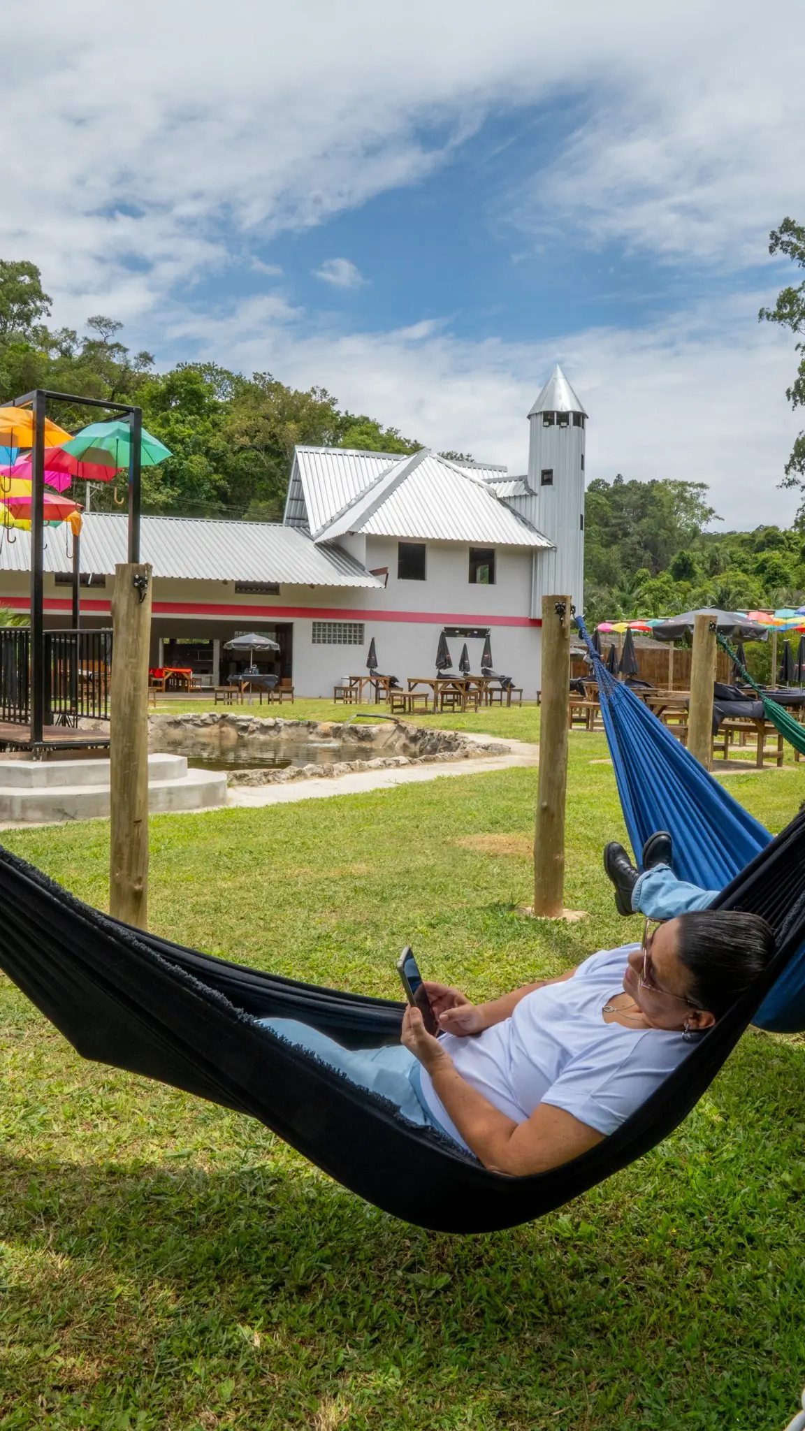 Rede de descanso armada no gramado com vista para o rancho